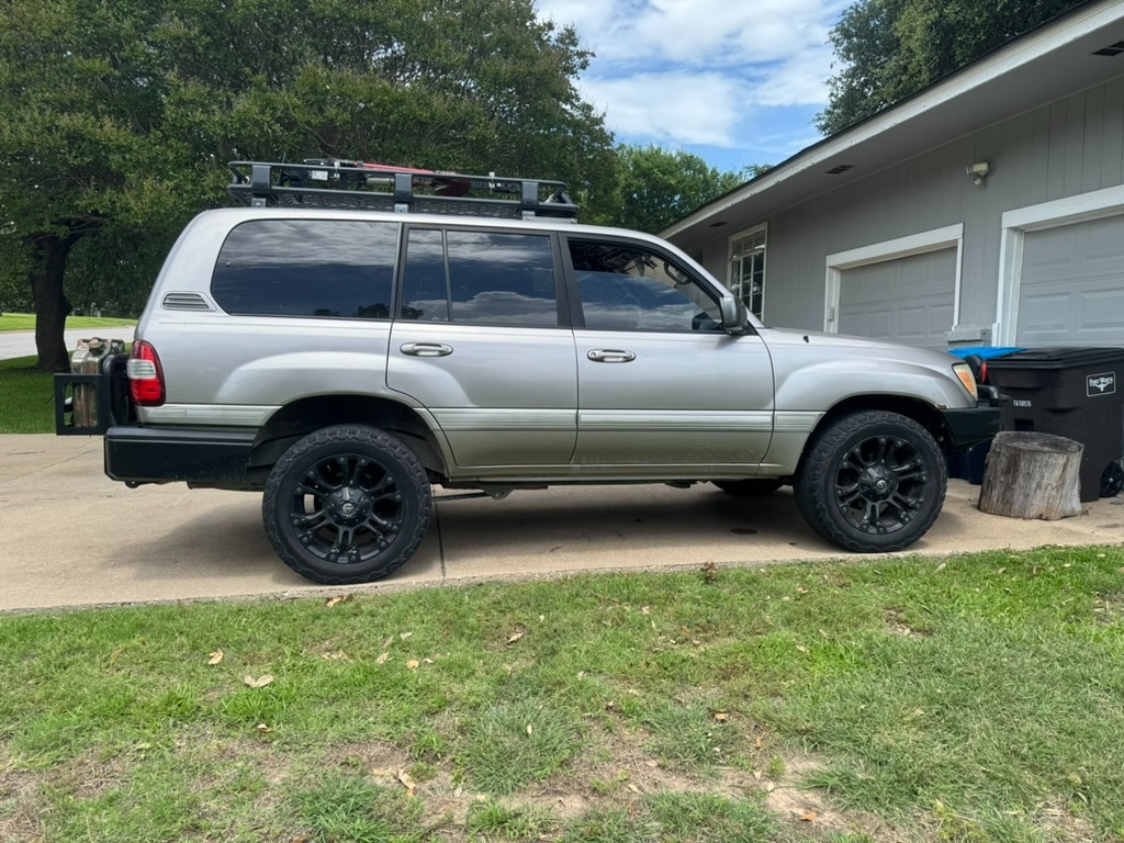 2002 Land Cruiser side profile, silver, lifted, Fuel matte black wheels on BFGoodrich All-Terrains, ARB front bumper, ARB rear bumper with jerry can carriers, roof rack