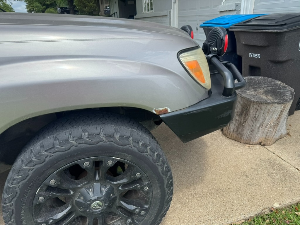 Front fender paint chip and honest patina on the Land Cruiser, preserved on purpose